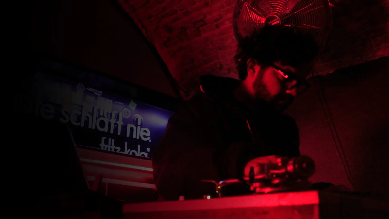 DENSO pinchando en vinilo en un club con luz roja